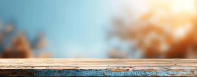 Wooden tabletop edge on soft blue and brown blurred background with copy space