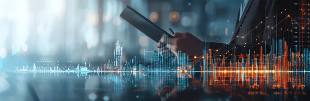 Businessman holding a tablet with glowing financial graphs over a blurred office scene.