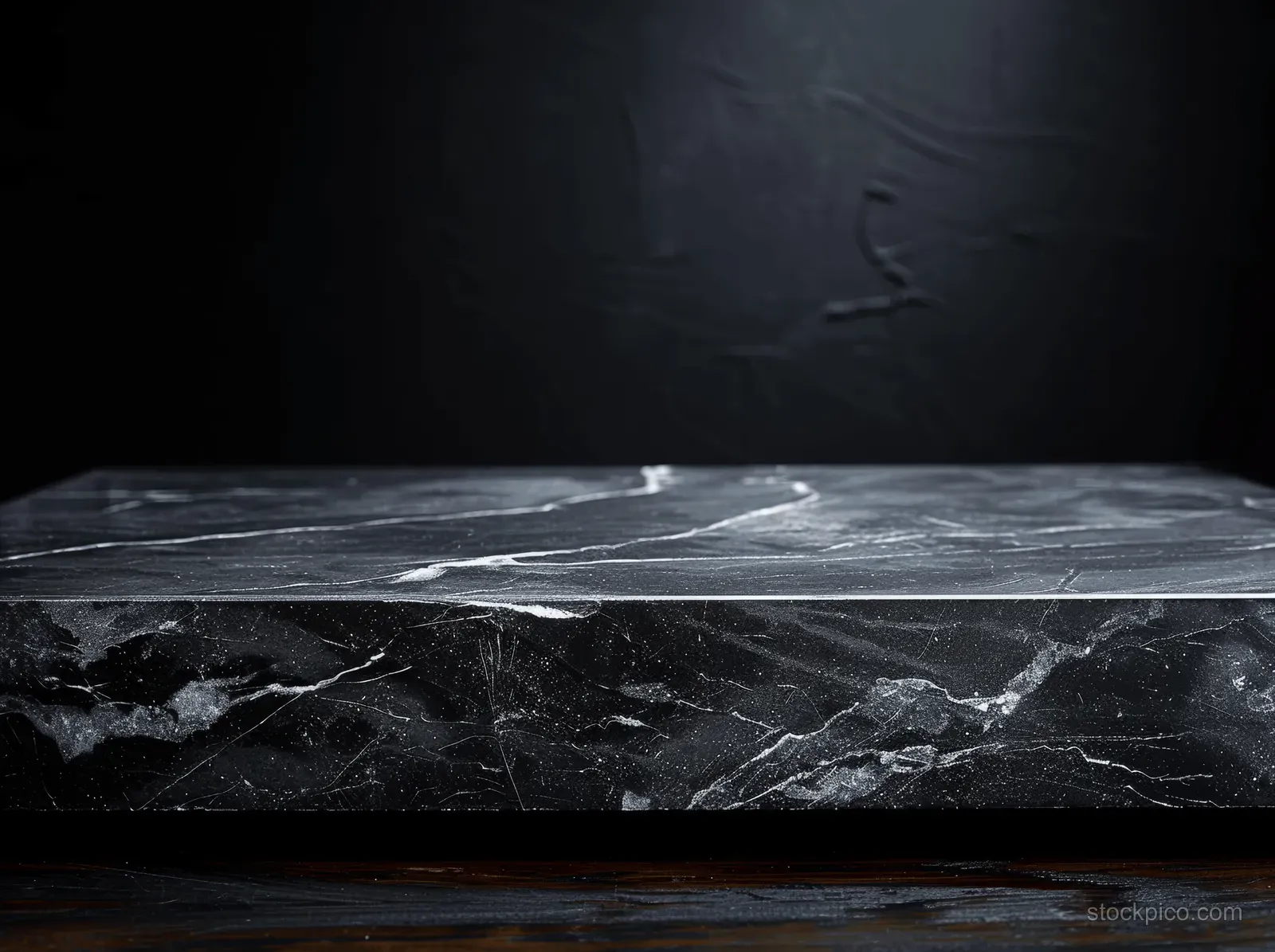 Black marble tabletop on a wooden surface against a dark, textured background, ideal for premium product displays.