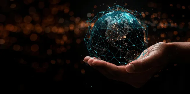 A hand holds a glowing digital Earth hologram with network links and data points on a dark background.