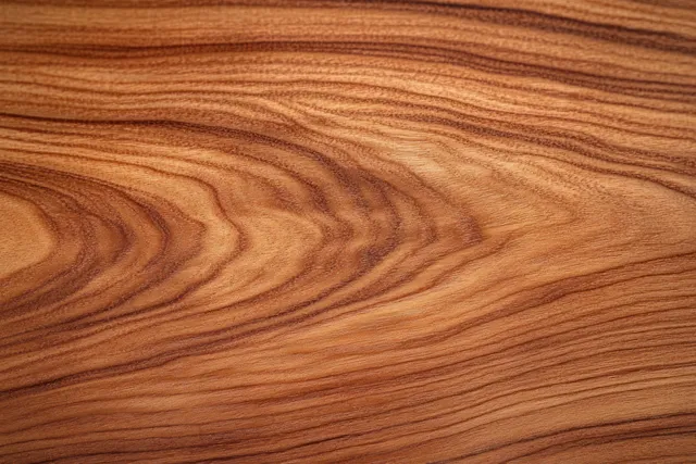 Polished cherry wood grain texture with warm brown swirls filling the background surface