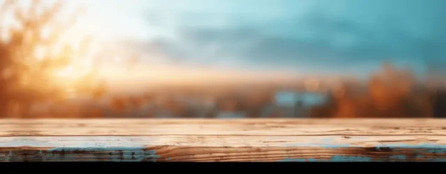 Blurry sunrise and sunset colors with warm bokeh reflect across a rustic wooden tabletop.