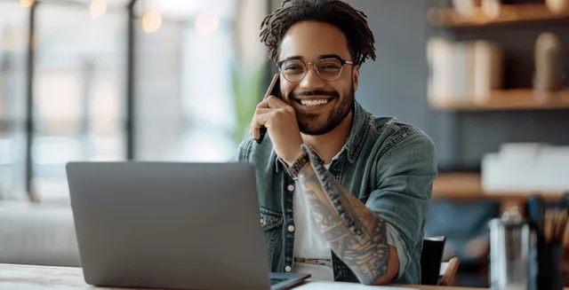 Smiling Software Designer on Phone in a Modern Office