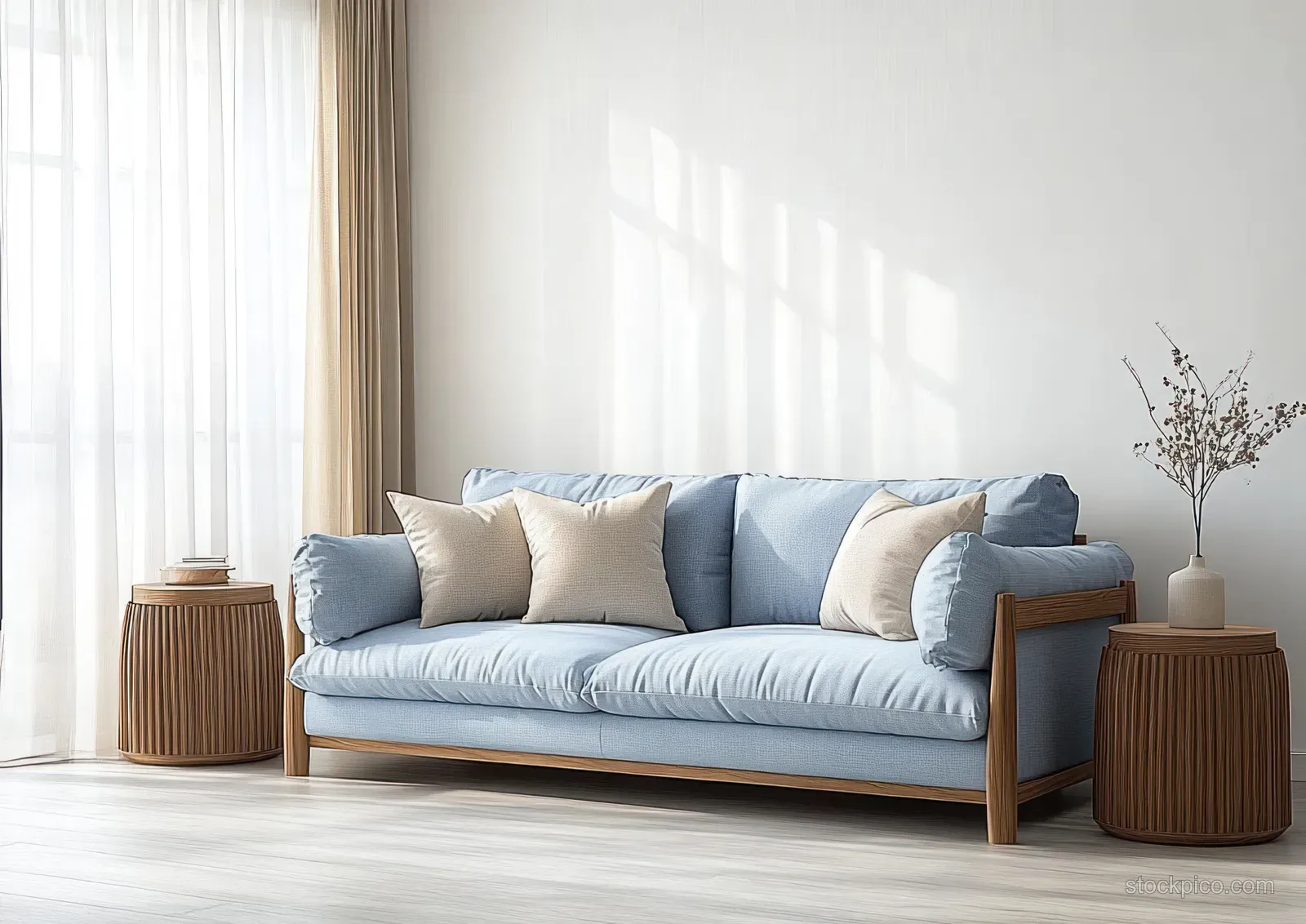 Light blue sofa with fluffy pillows in a minimalist living room, illuminated by sun through sheer curtains and flanked by wooden side tables.