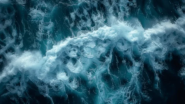 Aerial ocean waves with white foam over deep blue water