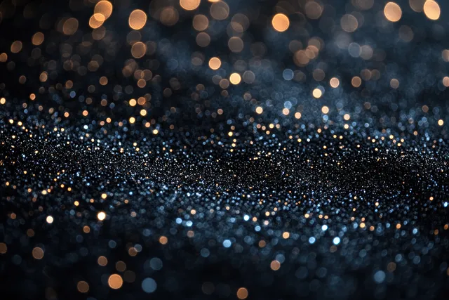 Shimmering bokeh light circles and sparkling dust glow across a dark night background.