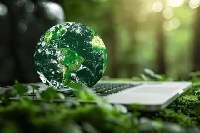 Globe on laptop on mossy forest floor with South America highlighted by sunlight