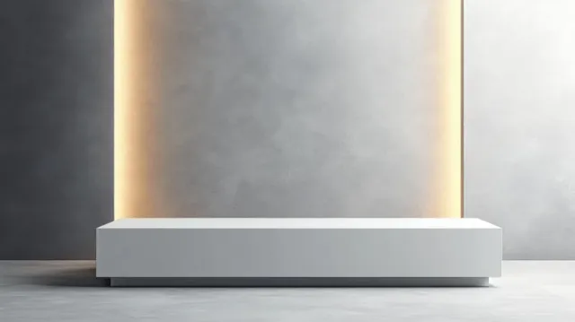 White exhibition counter placed on a spotlight-lit stage with an empty front panel for display branding.