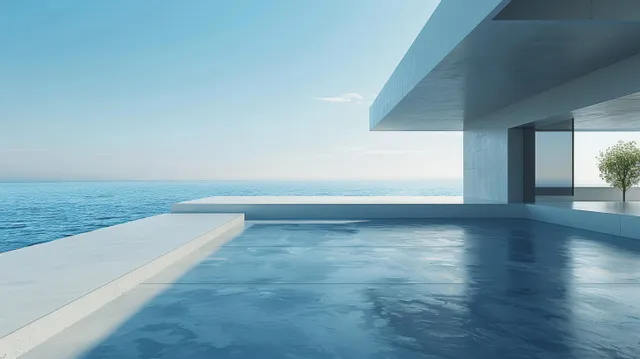Empty concrete terrace floor next to a modern building wall with an open sea horizon in the background.