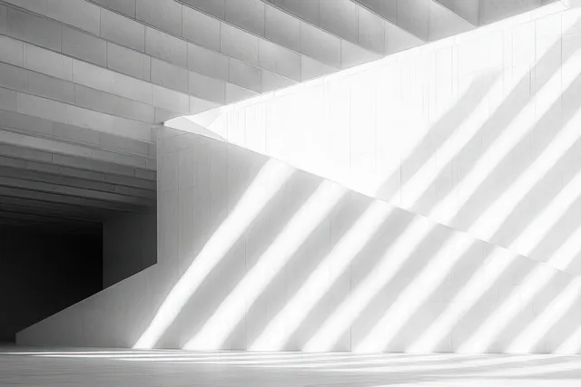 Minimal white interior with diagonal sunlight beams and striped shadows across angled walls
