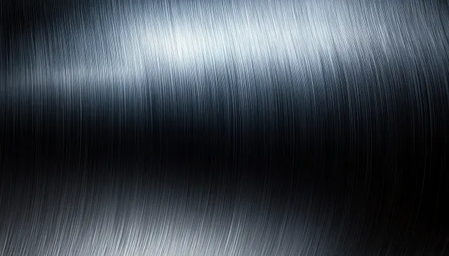 Brushed stainless steel background with fine linear grain and soft reflective highlights