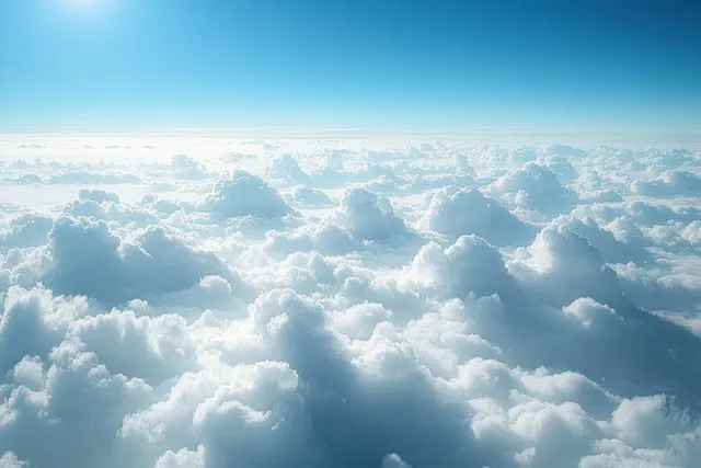 Aerial view of fluffy white cumulus clouds drifting under soft sunlight in clear blue sky