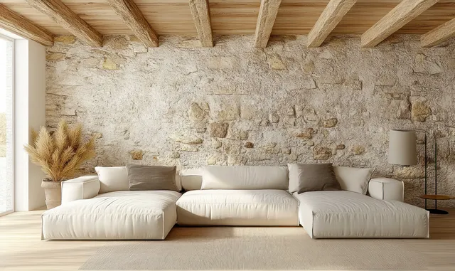 Cozy living room with white sectional sofa against textured stone wall and warm daylight