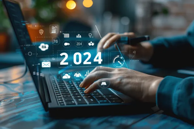 Businessman using AI dashboards to plan 2024 growth strategy on laptop with data overlays