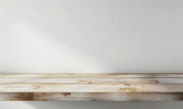 Light wooden tabletop edge against a plain white wall for clean product display mockup