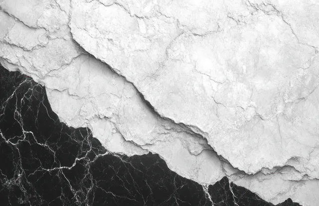 Layered white stone rests over black marble with visible white veins and rough stone texture.