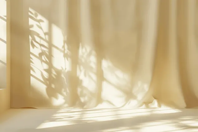 Minimal sunlit window shadows on light beige studio backdrop for product display