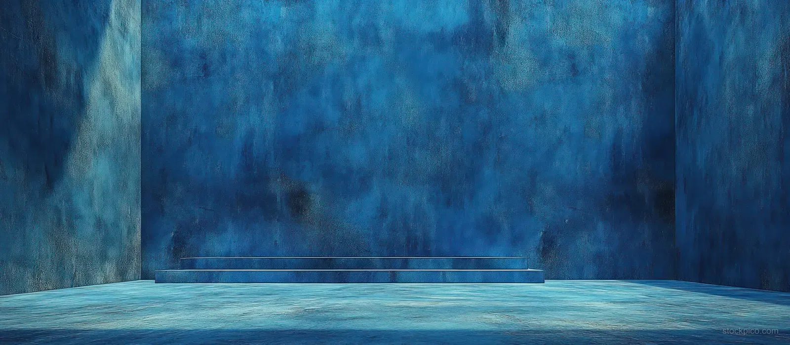 Deep blue textured wall and floor with cool rim lighting creating strong shadow and minimal interior depth.