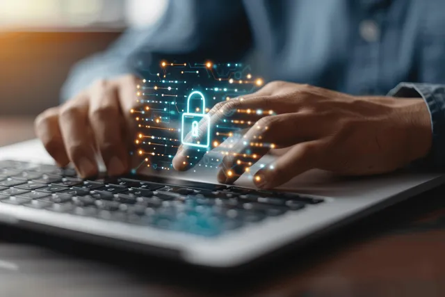 A person types on a laptop screen showing a glowing virtual padlock for secure login.