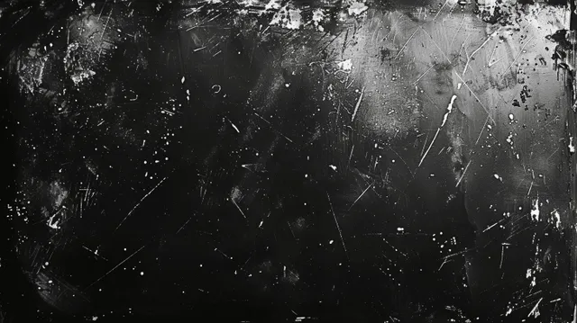 Monochrome grunge film background with dust specks and thin scratches across a dark textured surface.