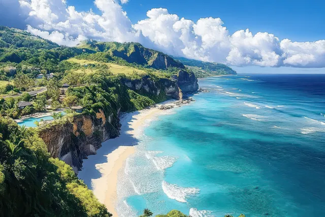 Turquoise waves roll onto a sandy beach below steep green cliffs beneath a bright blue sky and fluffy clouds.