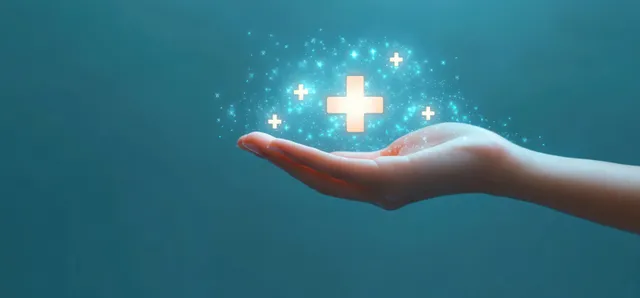 Open human hand offering glowing medical cross symbols amid sparkly light particles