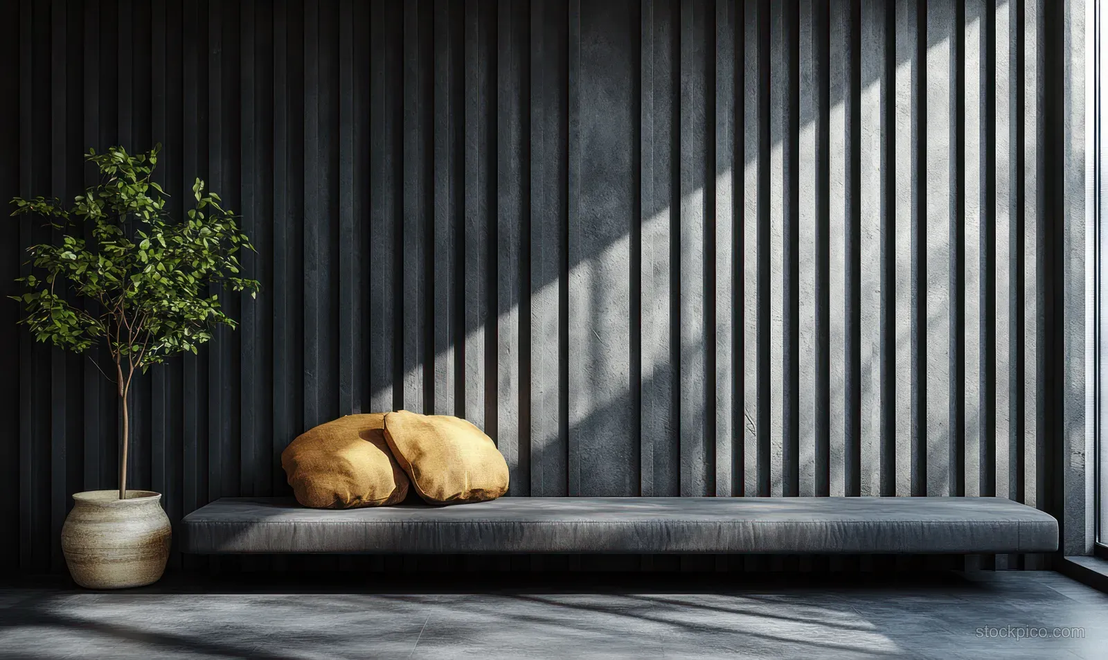 Minimalist lounge corner with a low daybed, dark vertical striped wall, and soft sunlit shadows on the floor.