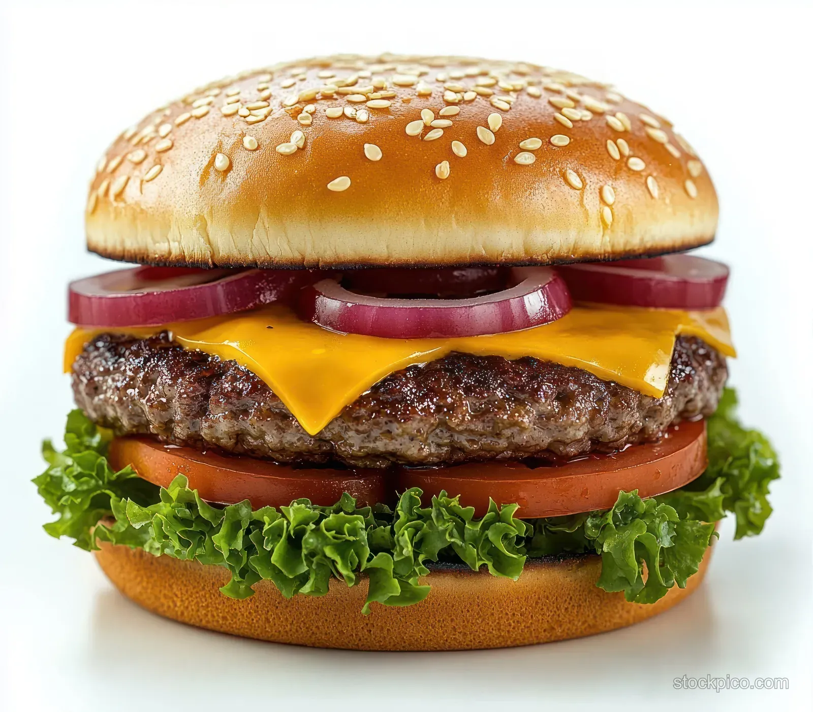 Close-up of a juicy cheeseburger with sesame bun, melted cheddar, grilled beef patty, lettuce, tomato, and red onion rings.
