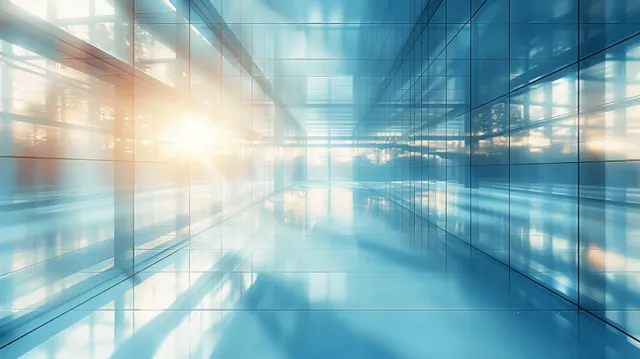 Glass-walled office interior with sunlit reflections and city skyline