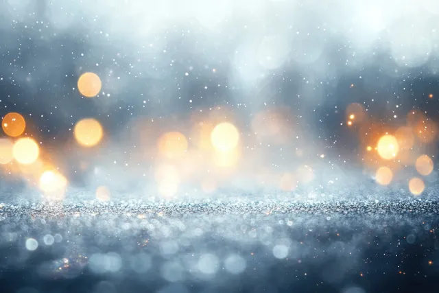 Silver and gold bokeh lights glow softly through a hazy snowfall atmosphere.