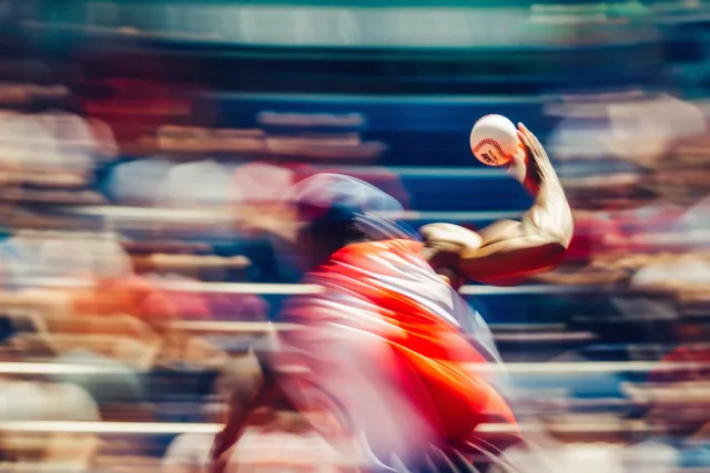 A USA discus thrower releases the discus in a stadium while the crowd and background blur from motion.
