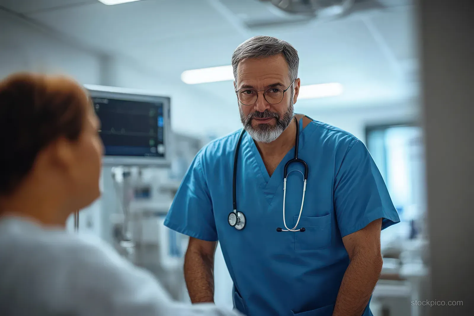 A doctor talks with an overweight patient in an emergency room while medical monitors glow in the background.