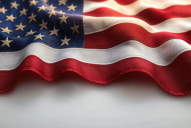 American flag waving in close-up with stars and stripes across soft white background