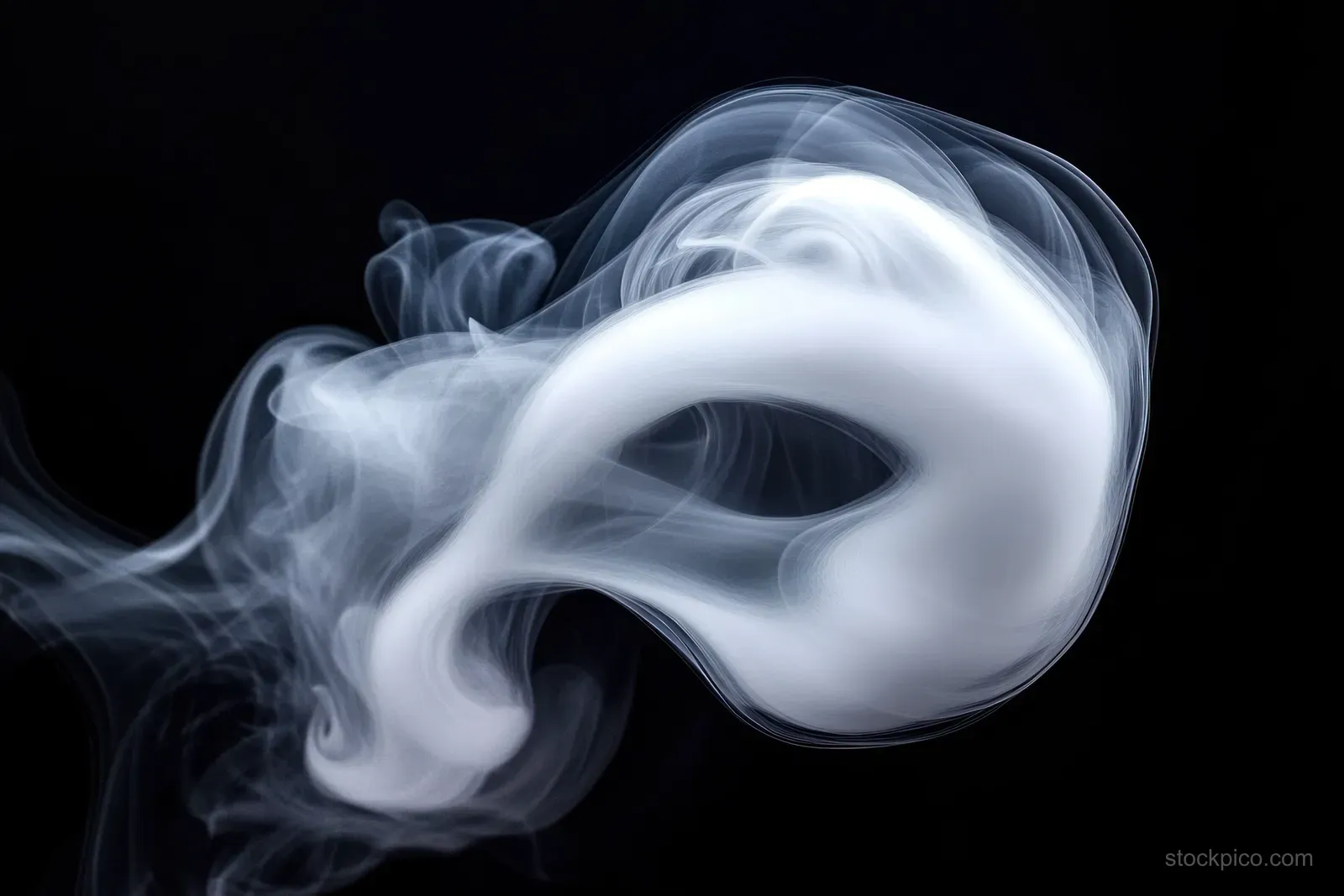 A white smoke ring curls and floats on a dark background with soft swirling wisps.