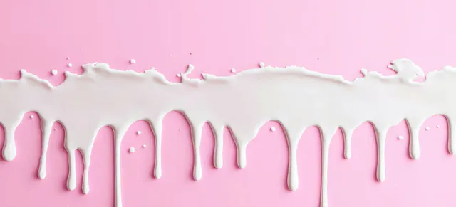 Thick white paint drips spill downward across a soft pink background with glossy texture.