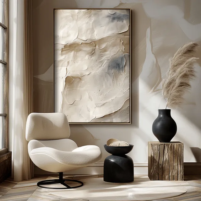 Beige chair and wood side table with black vase, white abstract painting, and light stucco wall interior.
