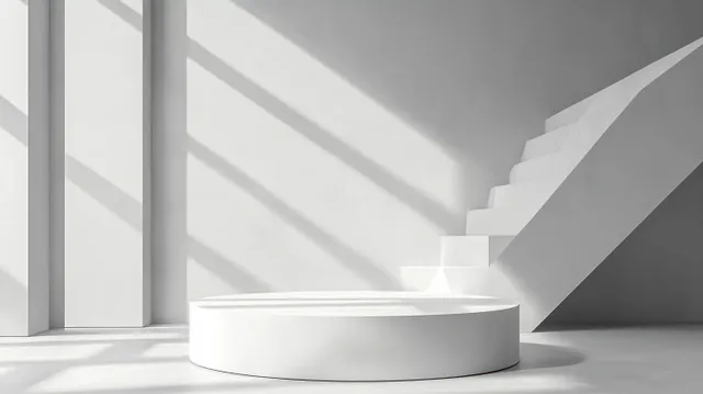 White minimalist interior with a round platform and staircase as sunlight forms diagonal shadows across smooth walls.