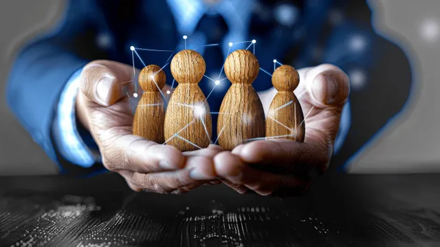 Hand holding worker figures symbolizing workplace authority and influence over employees