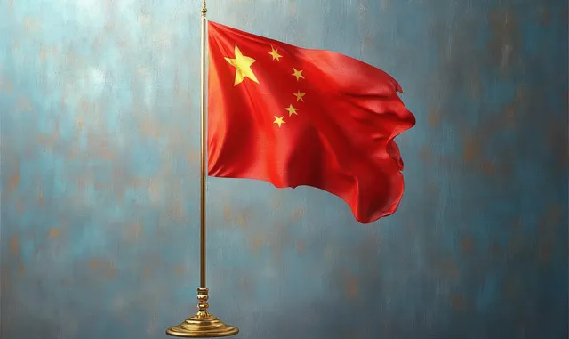 Red flag with yellow stars waves from a golden stand against a textured blue background.