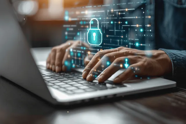 Hands typing on laptop with glowing padlock overlay for secure cybersecurity login