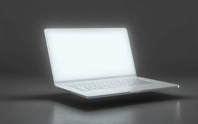 A slim laptop floats above a dark textured surface with a glowing screen in dim light.