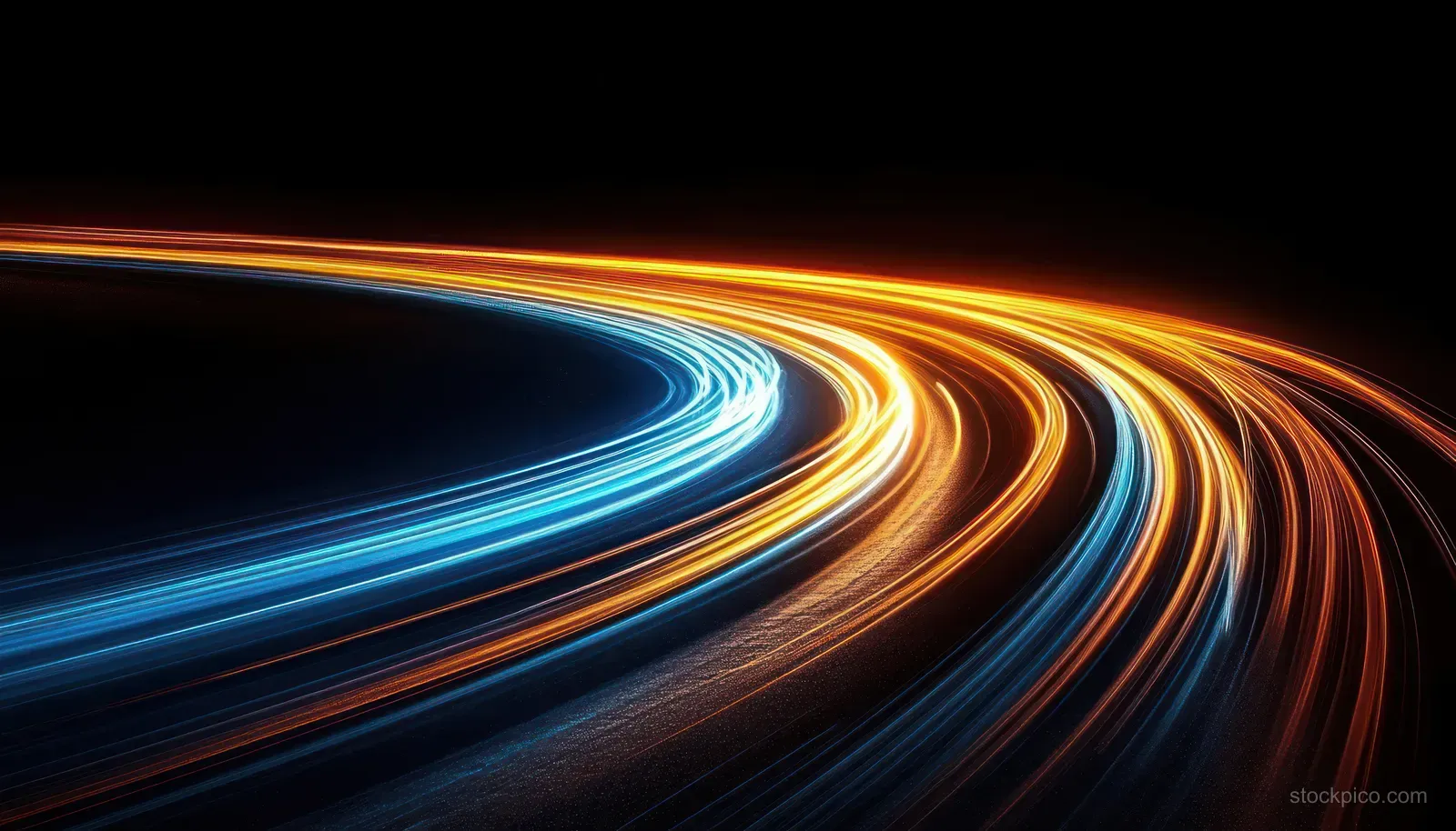 Curving night highway with long exposure car light trails forming blue and orange streaks.