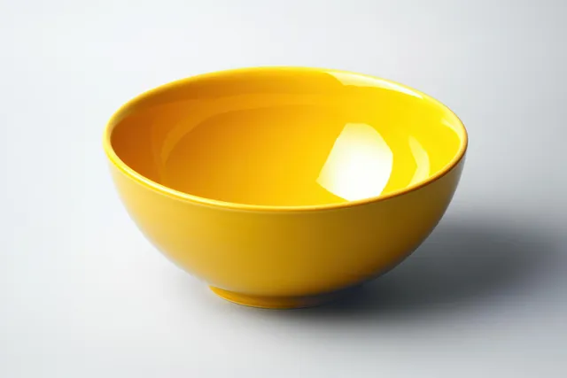 Bright yellow empty ceramic bowl on white background with glossy reflection