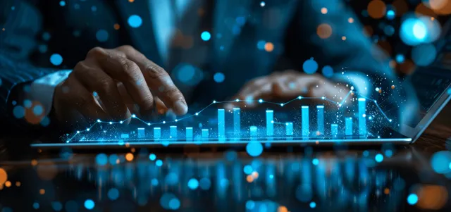 Businessman reviews growth charts on laptop while tablet shows digital financial dashboard projections