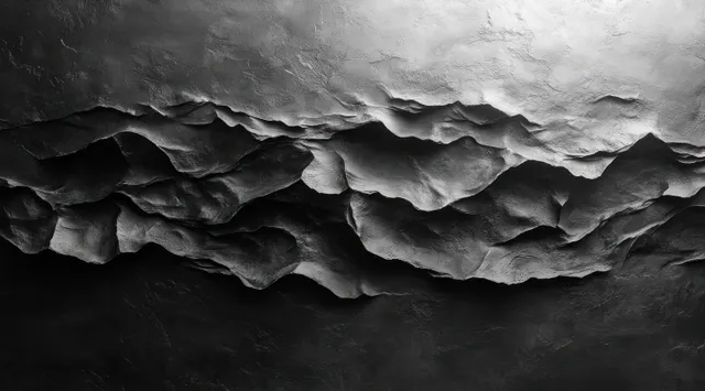 Crumpled black paper sheet on textured gray wall with dramatic chiaroscuro shadow