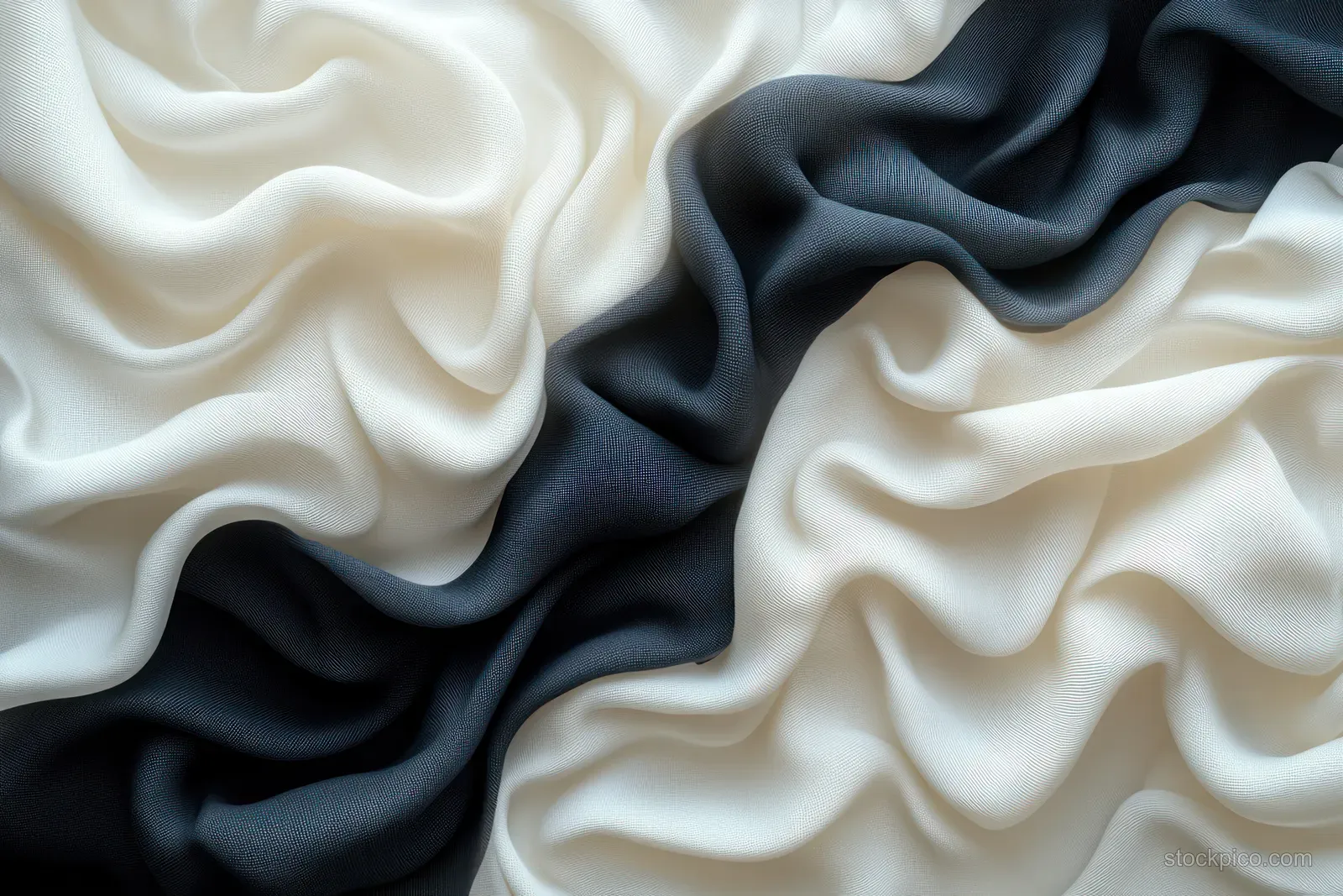 Black and white silk scarf fabric draped in soft, flowing folds with subtle shadows.