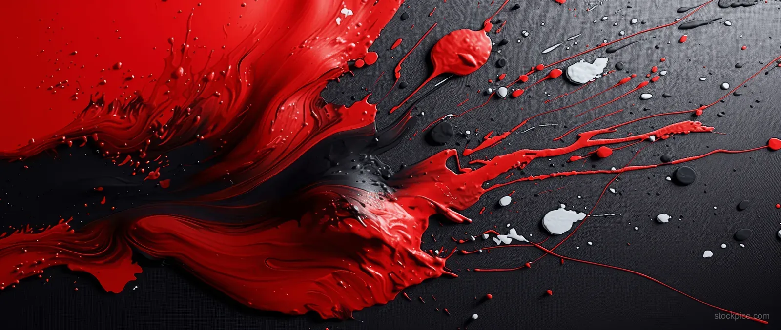 Red and black paint form sweeping arcs while white droplets splatter across a dark gritty surface.