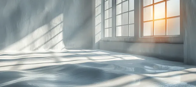 Soft sunlight shadows across a white wall beside an open window, blurred minimal interior