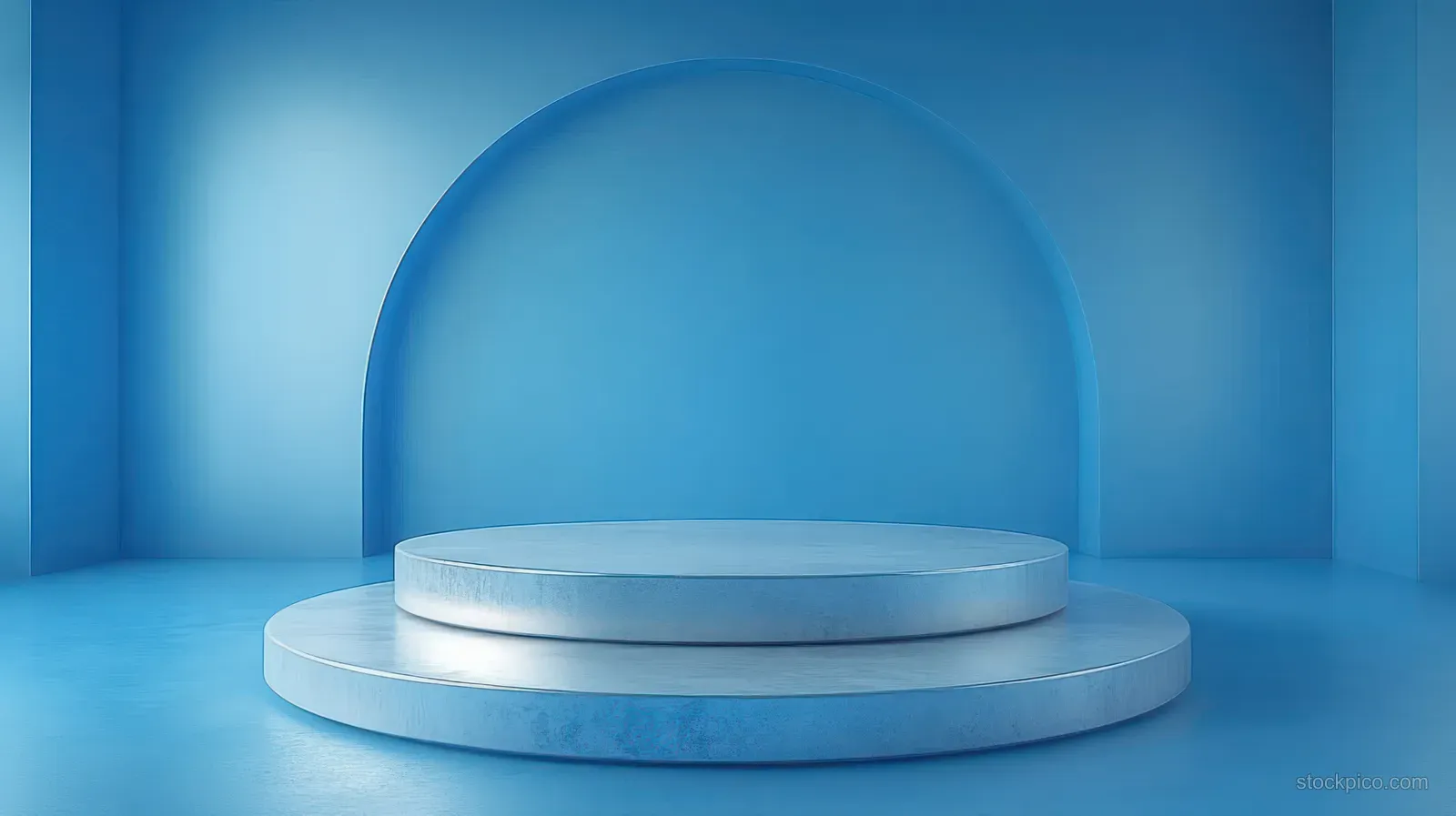 Minimal empty blue room showing a two-tier circular platform beneath a large arched opening.