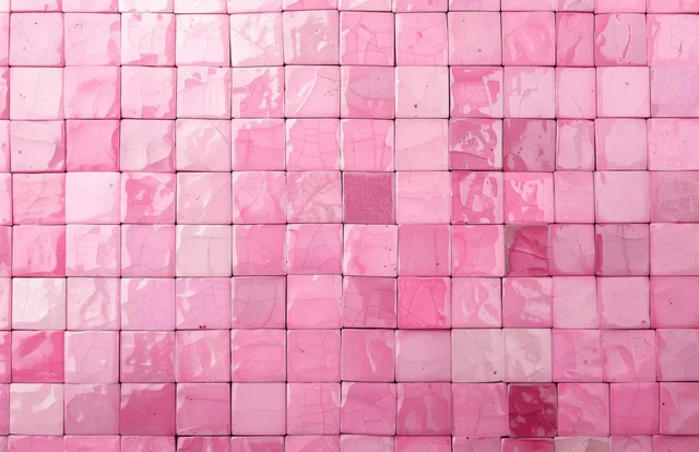 Pastel pink mosaic tiles form a geometric square pattern on a wall with visible grout lines and soft light reflections.